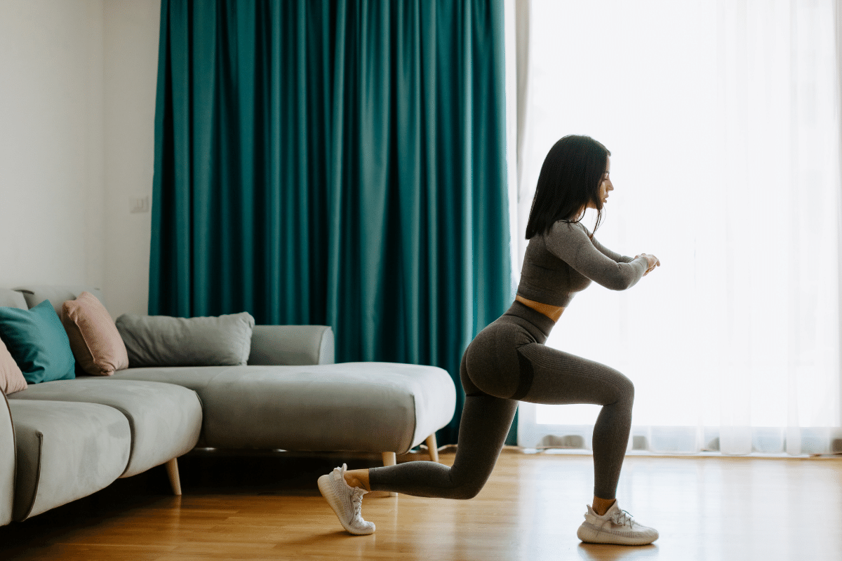 woman doing a lunge home workout in lounge
