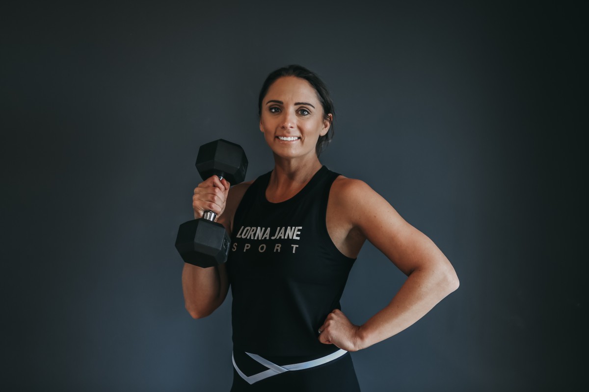 women holding a dumbbell with one arm