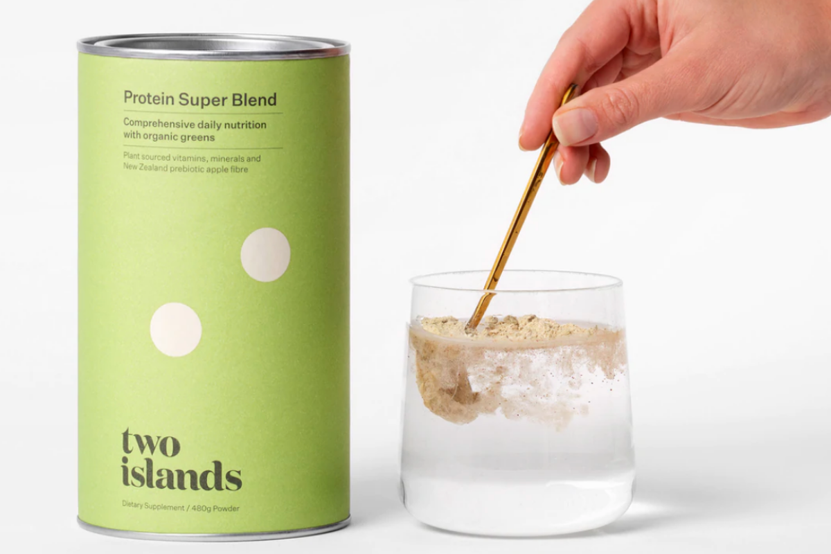 Two Islands Protein Super Blend being stirred in a glass of water