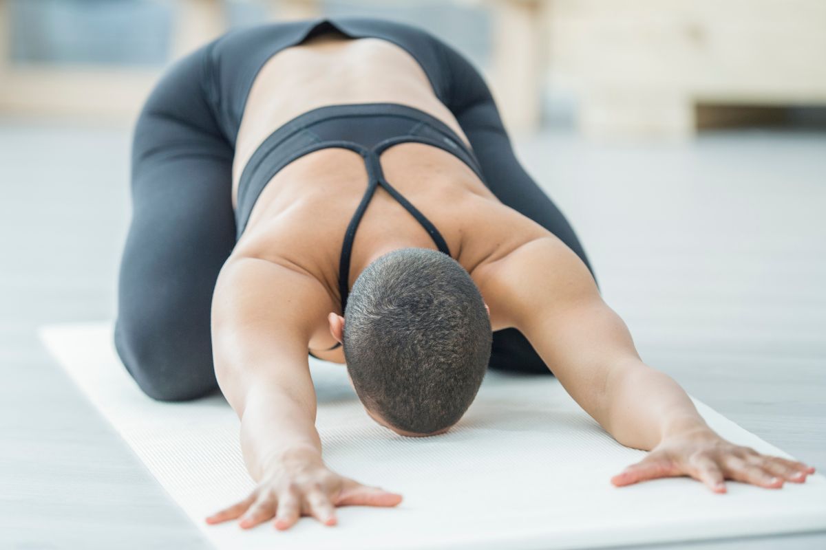 Woman doing child's pose on a yoga mat
