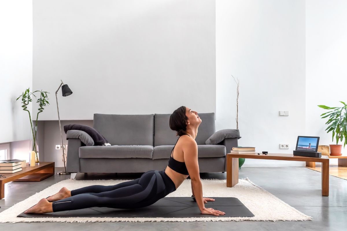 Female doing yoga cobra pose at home 