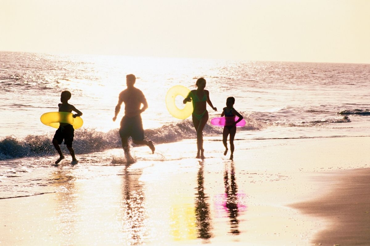 Family running and having fun on the beach