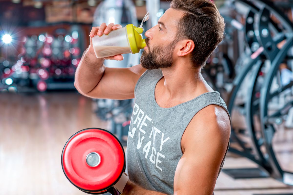Man drinking protein powder shake at the gym