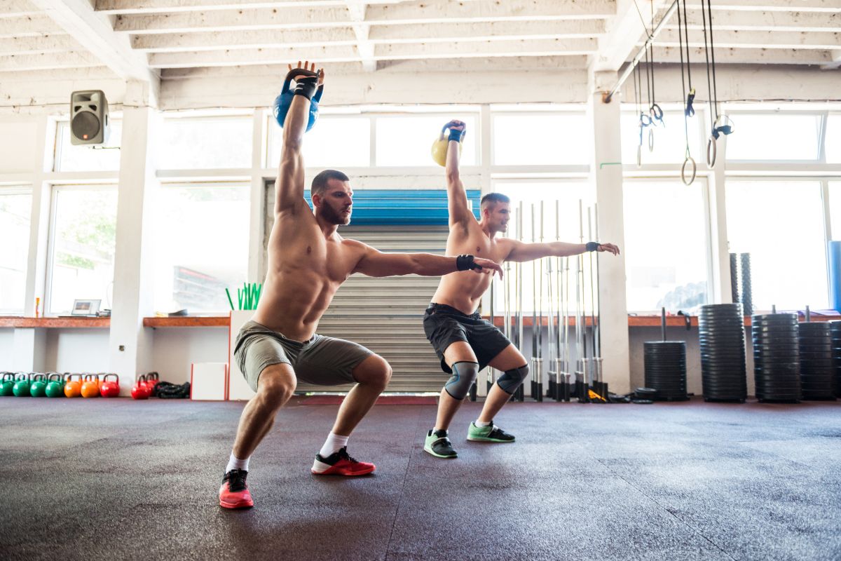 Two guys working out in a functional gym with kettlebells